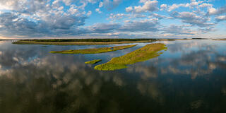 Beautiful afternoon clouds reflect in the calm water of the saltmarsh.